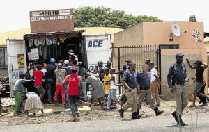 By Standers - Metro Police in Soweto taking no action as local residents loot a Somali shop.
